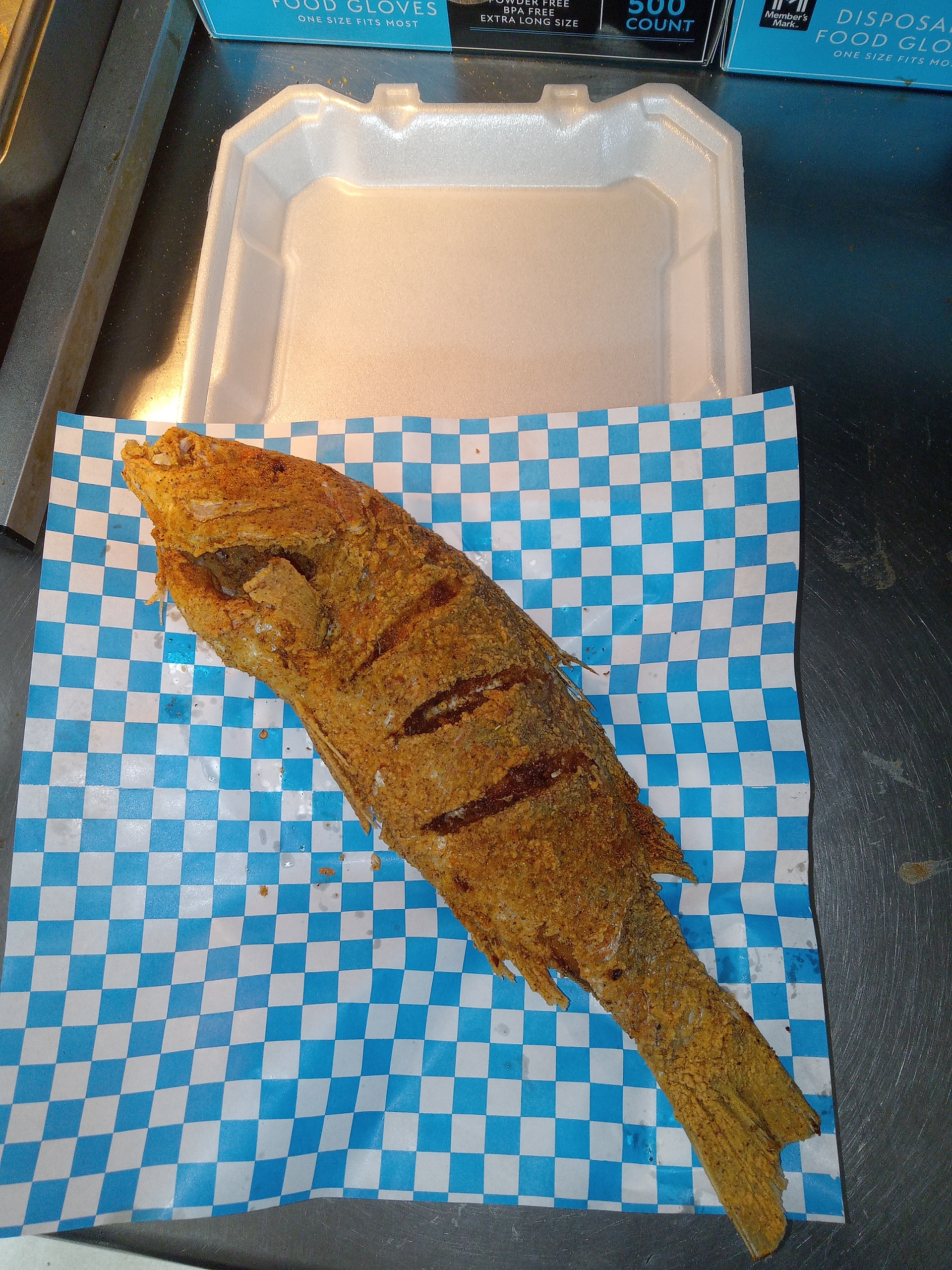 Whole fried fish on checkered paper