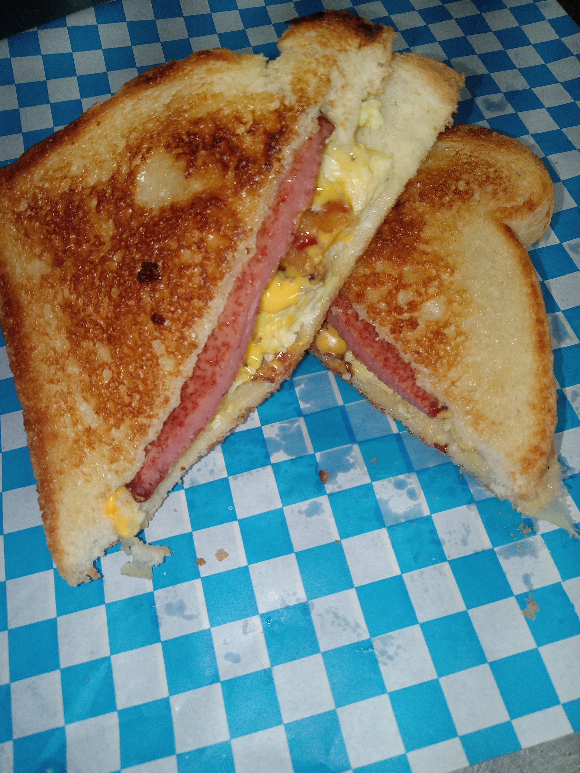 Grilled egg and meat sandwich on toasted white bread
